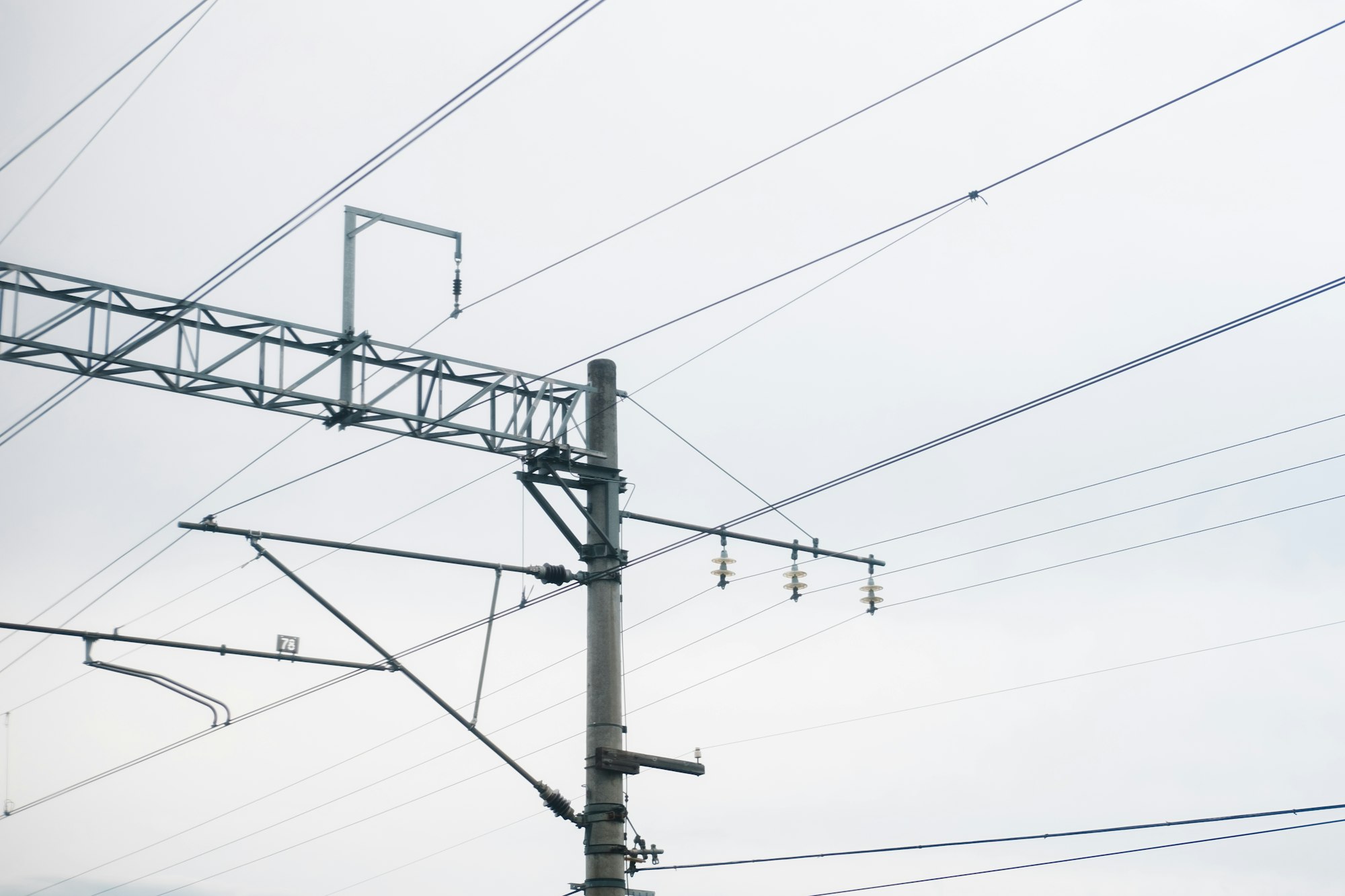 high-voltage wires over the railway. Power lines for the train, against the sky.